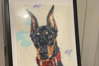 A finished brick mosaic of a Doberman in a black frame at home